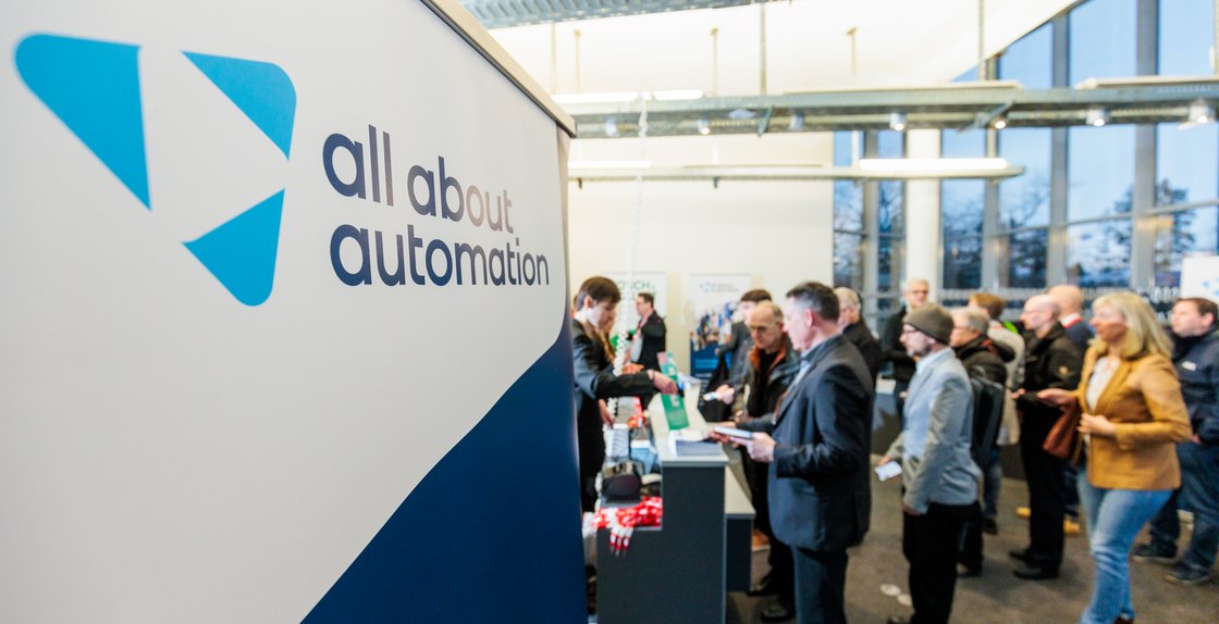 All about automation Im Vordergrund Logo der all about automation Messe, im Hintergrund viele Menschen
